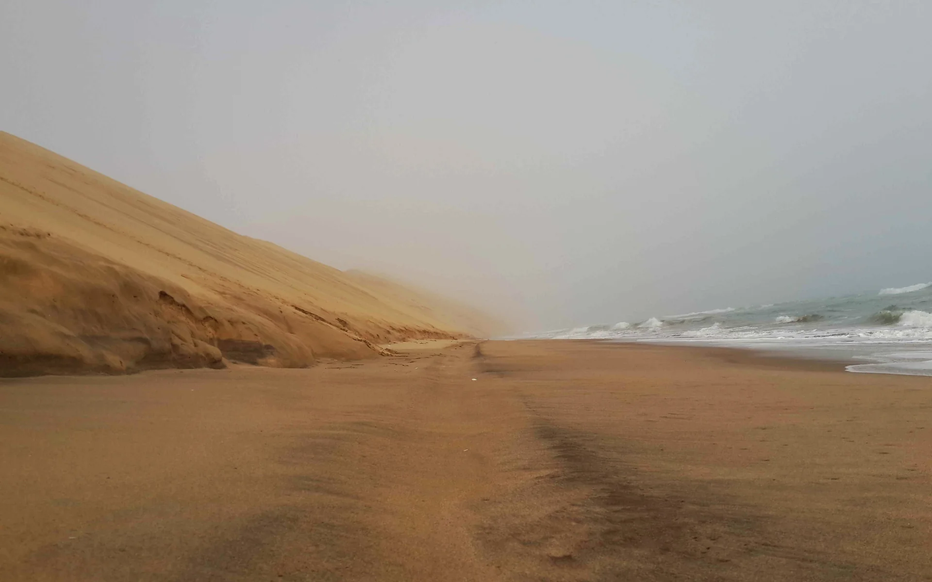 Sand dunes descending into the misty Atlantic on Namibia’s coast.